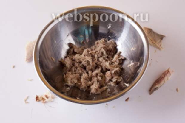 Пока картошка варится, руками растрёпываем копчёную скумбрию «в труху». Тщательно перетираем мясо подушечками пальцев, вычищая мелкие косточки.