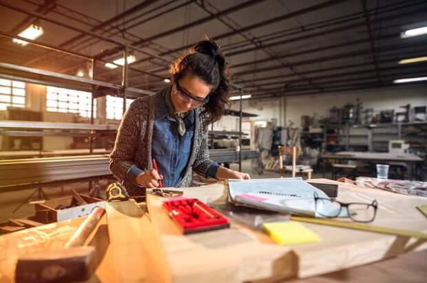 A woman working at a table in a workshop.