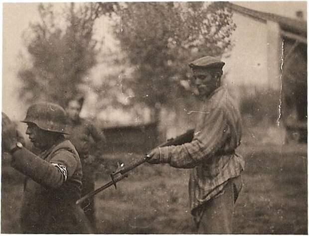38. Освобожденный еврей держит нацистского охранника под прицелом 38. Освобожденный еврей держит нацистского охранника под прицелом