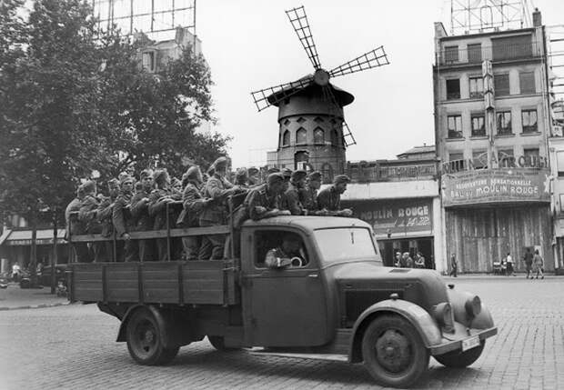 Немецкие солдаты проезжают мимо кабаре Мулен Руж. 8 августа 1940г. Немецкие солдаты проезжают мимо кабаре Мулен Руж. 8 августа 1940г.