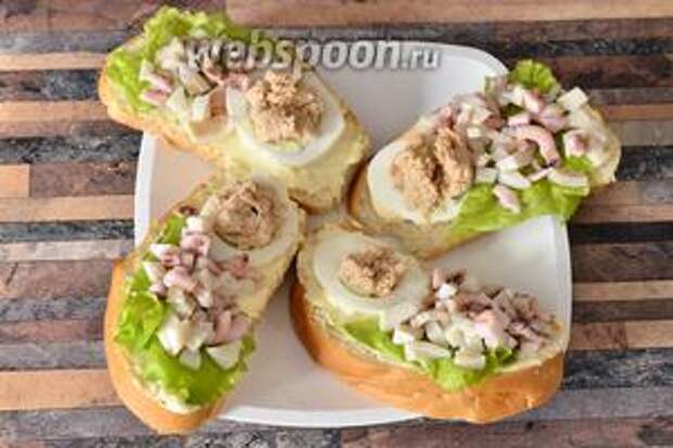 Затем раскладываем нарезанных кубиками осьминогов и кальмаров. Бутерброды готовы. Приятного аппетита!