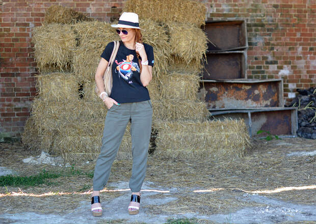 Black graphic tee with Panama hat, khaki track pants, strappy platforms