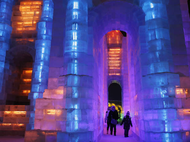 People visit ice sculptures illuminated by coloured lights during a trial operation ahead of the 31st Harbin International Ice and Snow Festival in the northern city of Harbin, Heilongjiang province, January 4, 2015. 