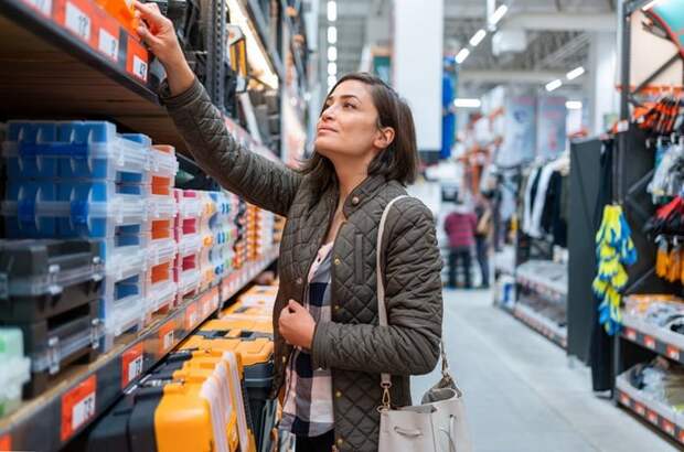 Shopper inspecting items in home improvement aisle