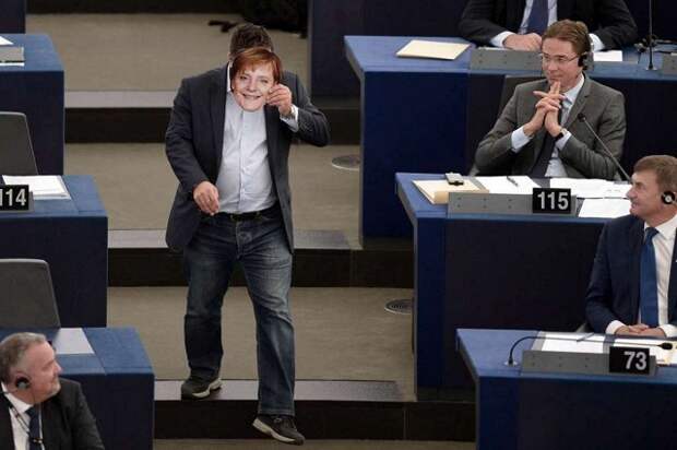 Евродепутат в маске Ангелы Меркель прервал выступление главы Еврокомиссии. Мужчина встал со своей трибуны, подошел Юнкеру и пожал ему руку