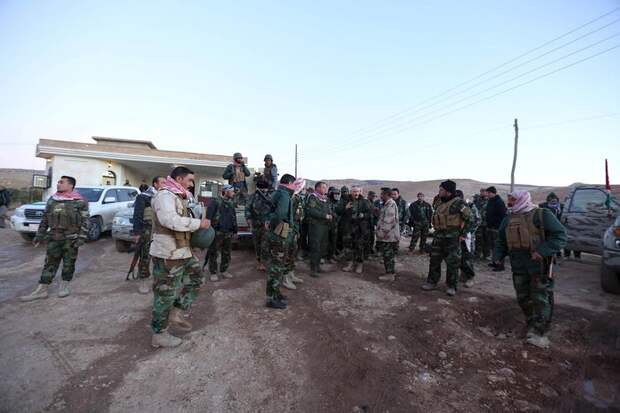 Members of the Kurdish peshmerga forces gather in the town of Sinjar