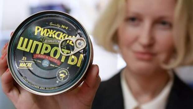 Девушка демонстрирует рыбные консервы Рижские шпроты Вентспиллского рыбоконсервного комбината. Архивное фото
