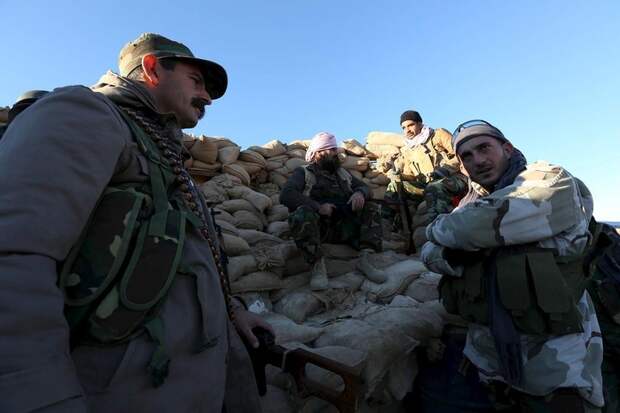 Members of the Kurdish peshmerga forces gather in the town of Sinjar
