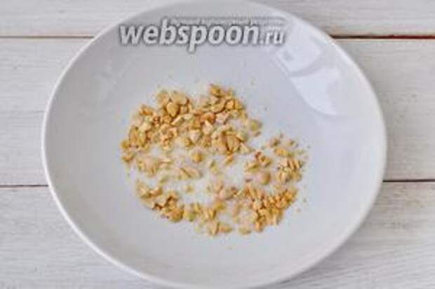 Орешки порежем ножом и смешаем с сахаром в широкой посуде.