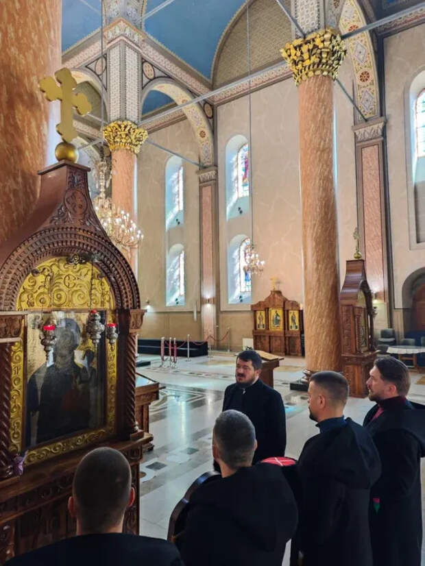 Паломники перед чудотворным древним образом Богородицы и отец Неманяю.jpg