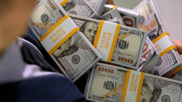 man holding several stacks of money