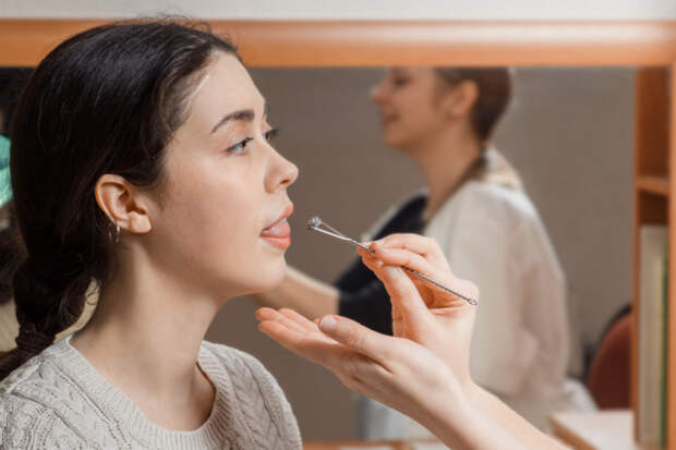 The doctor makes a massage of the girl's tongue, to bring it to tone