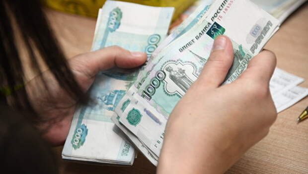 Работник почтамта пересчитывает деньги