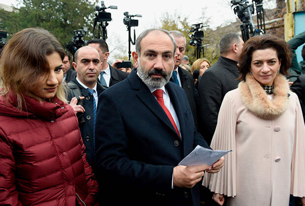 Никол Пашинян, его супруга Анна Акопян (справа) у избирательного участка во время внеочередных выборов в Национальное собрание (парламент) Армении
