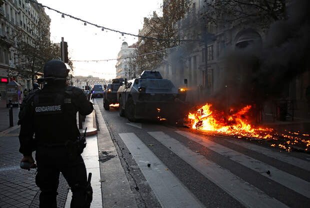 Бронеавтомобиль сдвигает горящую машину в Марселе