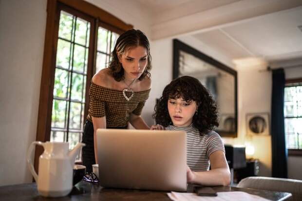 A concerned couple calculates their home finances together using a laptop.