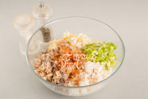В отдельной посуде соединяем вареный рис и яйца, рыбные консервы и два вида лука