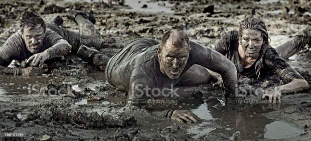 group of friends crawling in mud group of friends crawling in mud Mud Stock Photo