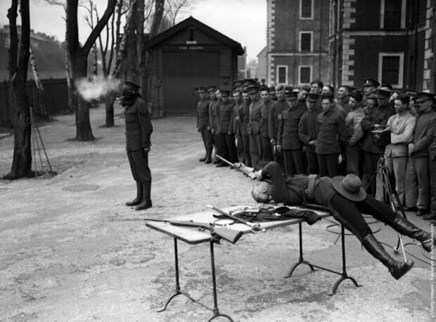 Капитан Джордж Эш лежа на спине, стреляет по глиняной трубке которую держат в зубах. 1932 история, люди, мир, фото