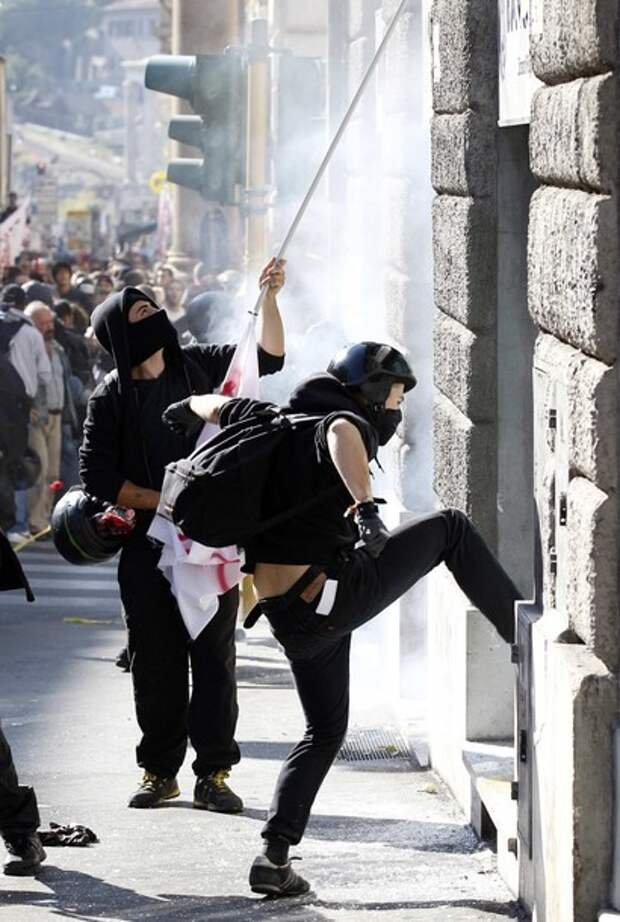 Demonstrators attempt to break through the entrance of a bank branch during a demonstration of the 'Indignant' group against banking and finance in Rome