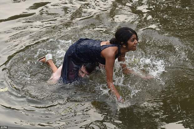 One woman fell head-first into the water after attempting to clamber onto her male companion's shoulders