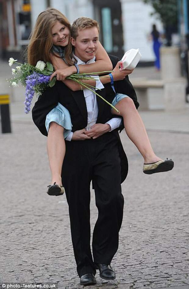 Clutching a box of takeaway food, one guest is given a lift from her male companion after partying the night away