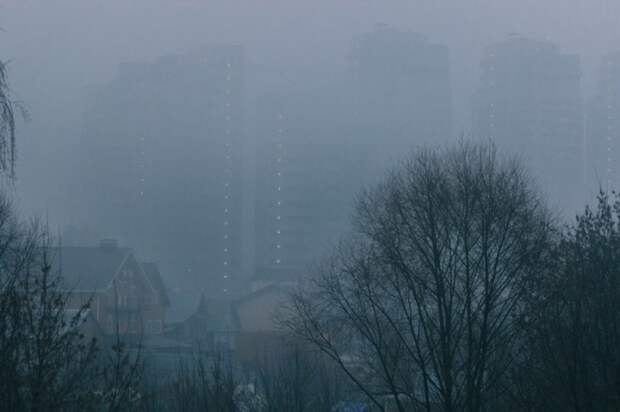 Вечерний город в голубой туманной дымке.