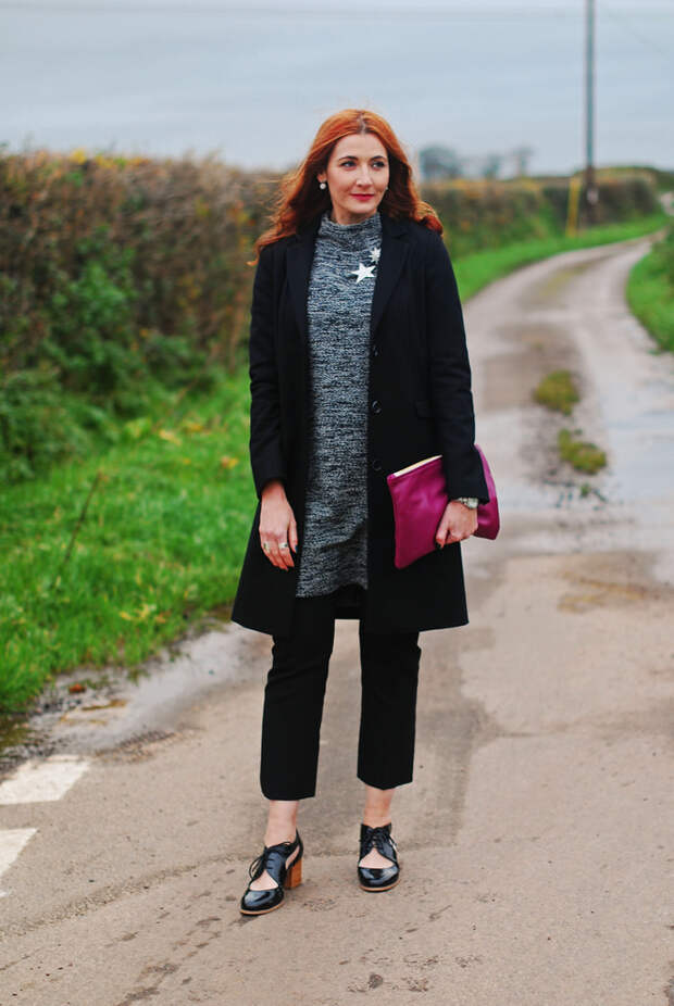 Grey sweater dress layered over black trousers, longline black coat