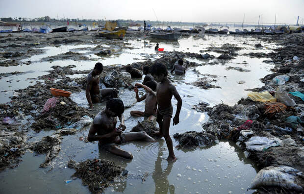 Indian men search for coins and gold in the polluted waters of the Ganga river at Sangam after the Kumbh Mela festival, in Allahabad on April 2, 2013. The two month long Kumbh Mela, celebrated every 12 years at the conjunction of two sacred rivers on the outskirts of the northern Indian city of Allahabad, drew massive crowds of devotees, ascetics and foreign tourists till its conclusion on March 10. AFP PHOTO/SANJAY KANOJIA
