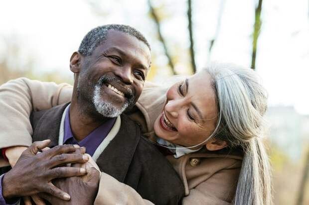 Two people smiling and hugging.