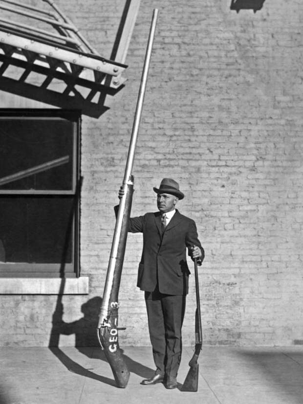 Глава егерской службы США демонстрирует изъятое гладкоствольное ружье длиной 3,25 метра весом 115 кг, которое использовалось для охоты на уток, 1920 год. | Фото: rarehistoricalphotos.com.