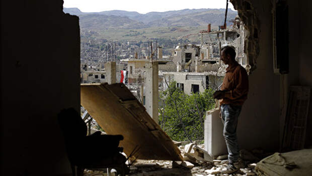 Мужчина смотрит на руины в окрестностях Дамаска после авиаударов коалиции во главе с США. Архивное фото