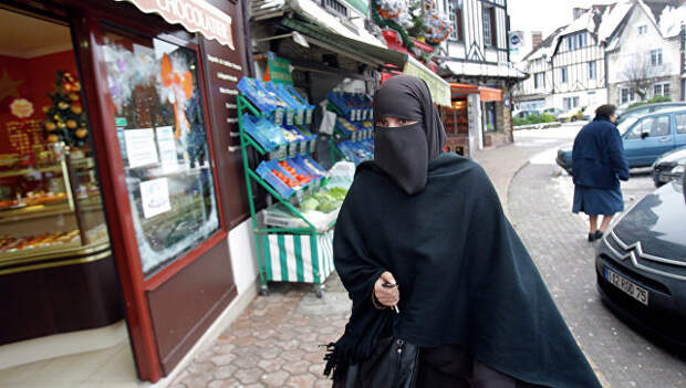 Девушка в мусульманской одежде на улице Ле Мениль-Сен-Дени, Франция