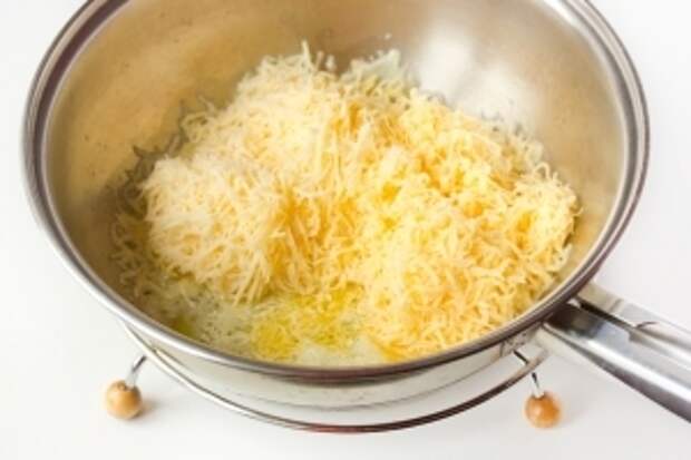 На сковороде растапливаем оставшееся сливочное масло, всыпаем натёртый на мелкой тёрке твердый сыр.