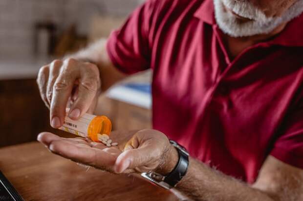A person pouring pills into their hand.