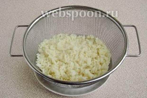 Рис тщательно промыть в нескольких водах до полного исчезновения мути. Бульонный кубик растворить в 0,5 л воды, довести до кипения, выложить в него рис и отварить его до мягкости, а затем выложить на дуршлаг и остудить.