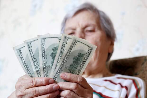 Someone holding five $100 bills in their hands.