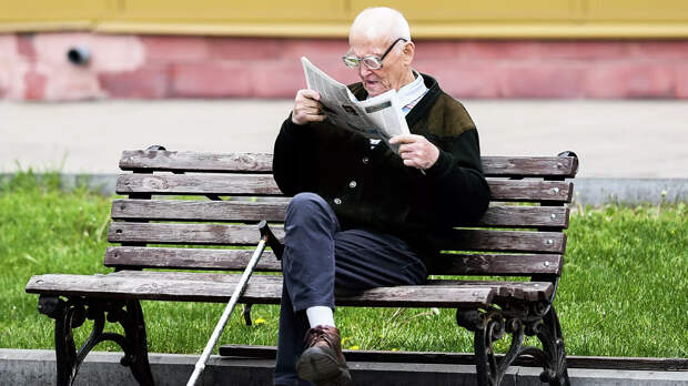 Мужчина читает газету на улице на лавочке в Москве - РИА Новости, 1920, 29.10.2020