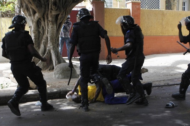 Riot police attack a demonstrator during a demonstration in Senegal's capital Dakar