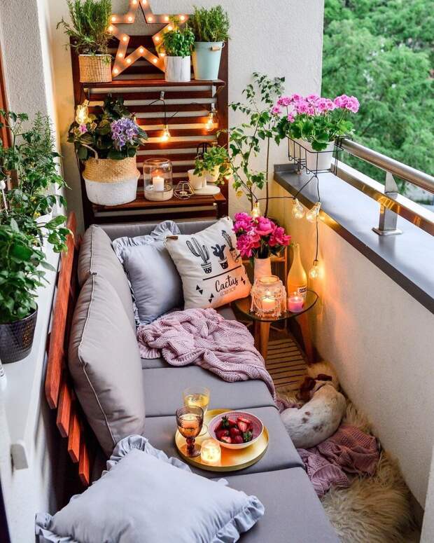 Песелю явно нравится отдыхать на этом балконе, который как будто создан для идеального свидания на свежем воздухе. Много зелени, яркий букет цветов, диванчик с подушками, освещение и свечки... М-м-м, ляпота