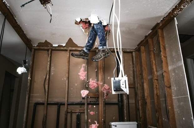 Someone's legs breaking through the ceiling of a room from above.