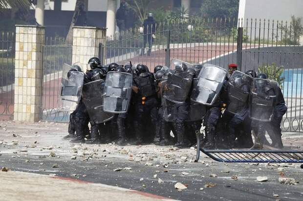 Riot police use their shields against a barrage of stones thrown by protestors in Senegal's captial Dakar