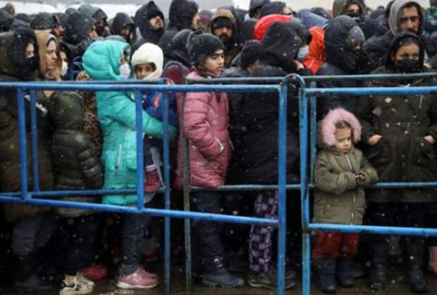 Migrants gather during snowfall at the transport and logistics centre Bruzgi on the Belarusian-Polish border, in the Grodno region, Belarus November 27, 2021. REUTERS/Kacper Pempel