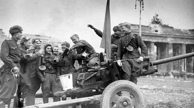 Артиллеристы, танкисты и пехотинцы Красной армии возле 76-мм пушки ЗиС-3 выпивают за Победу у Бранденбургских ворот в Берлине. Великая Отечественная война, СССР, Солдаты моей страны