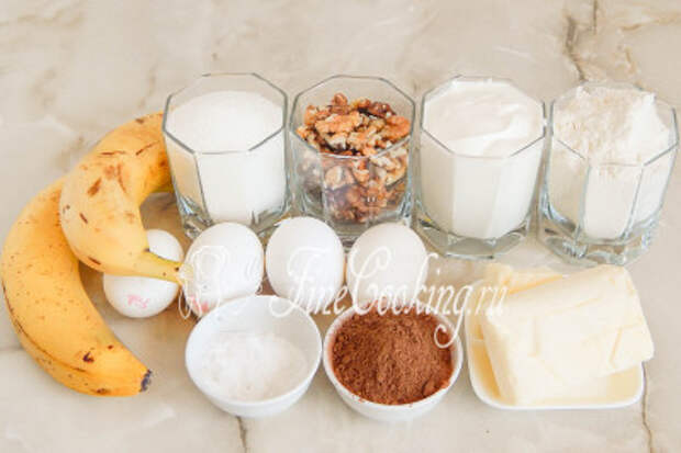В рецепт шоколадно-бананового кекса входят следующие ингредиенты: мука пшеничная, бананы, сахарный песок, сливочное масло, очищенные грецкие орехи, куриные яйца, несладкий какао-порошок, сметана и пищевая сода