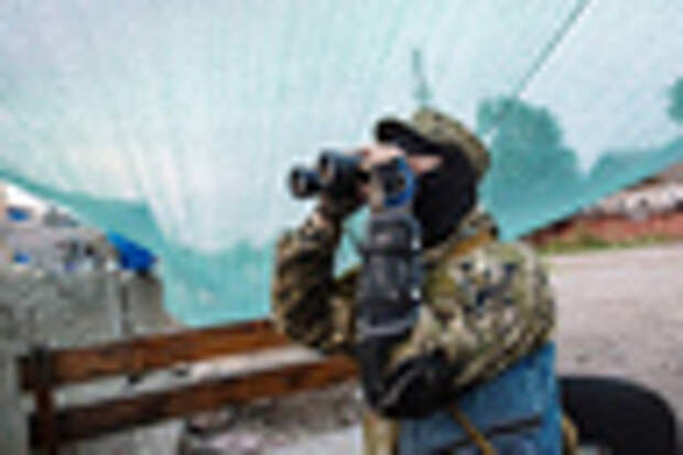Боец народного ополчения Донбасса наблюдает за передвижением украинских военных