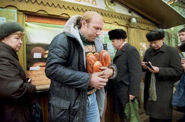 Мужчина уходит от хлебного киоска с несколькими буханками хлеба. Доллар США в настоящее время стоит 398 рублей, а средняя месячная зарплата в России составляет примерно 5000 рублей (12 долларов США) в месяц, 3 ноября 1992 года