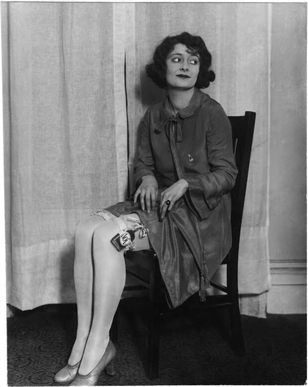Женщина демонтрирует потайное место для пронесения фляги с алкоголем. ок.1920 гг.  Фото: Courtesy of John Binder Collection.