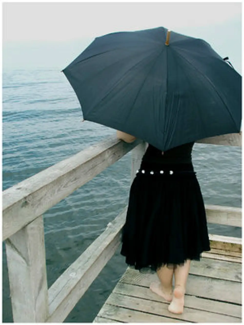 Девушка под зонтом в дождь со спины