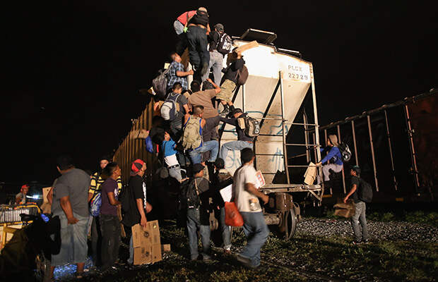 Мексиканцы залезают на грузовой поезд, направляющийся к границе с США